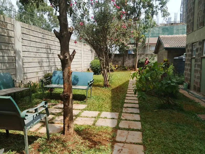 Seating area under a tree with stepping-stone paths, KMA residence