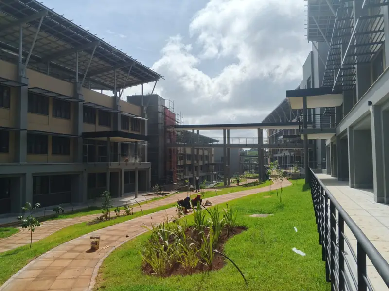 After: Completed courtyard at the UN complex in Nairobi: paved path, lawn and a planted island between new office blocks