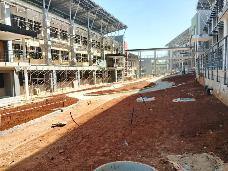 Before: The same UN courtyard during construction: bare red soil and drainage chambers