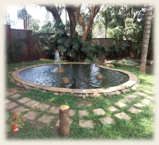 Circular pond with a fountain and stepping-stone surround in an office compound